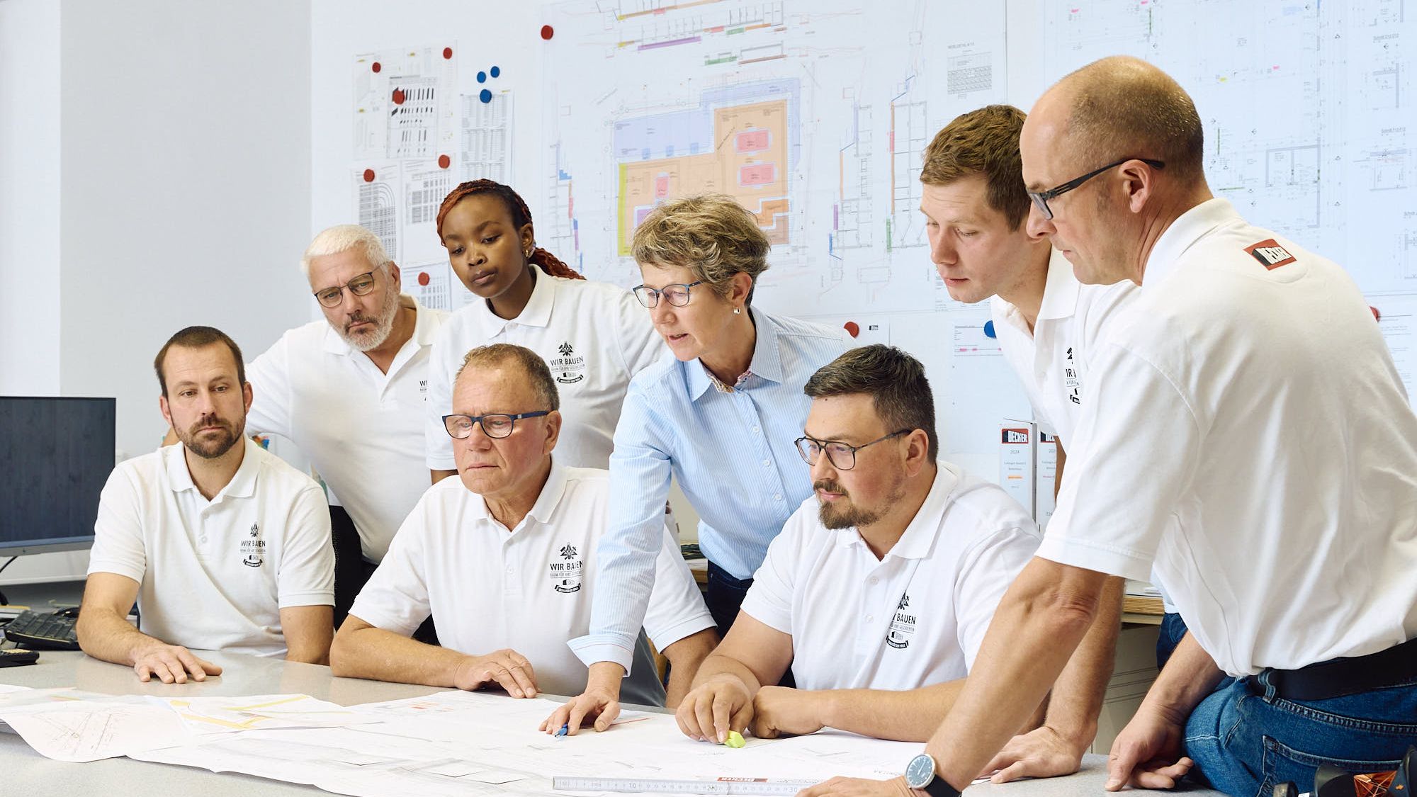 Team des Bauunternehmens Decker bei der Zusammenarbeit im Büro